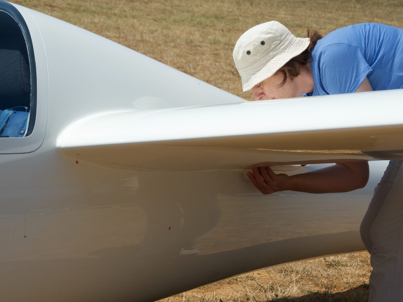 Valérie Mansard touche la jonction entre l’aile et le fuselage du planeur pour en comprendre la forme.